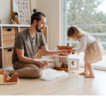 A child and an adult engage in activity with toys